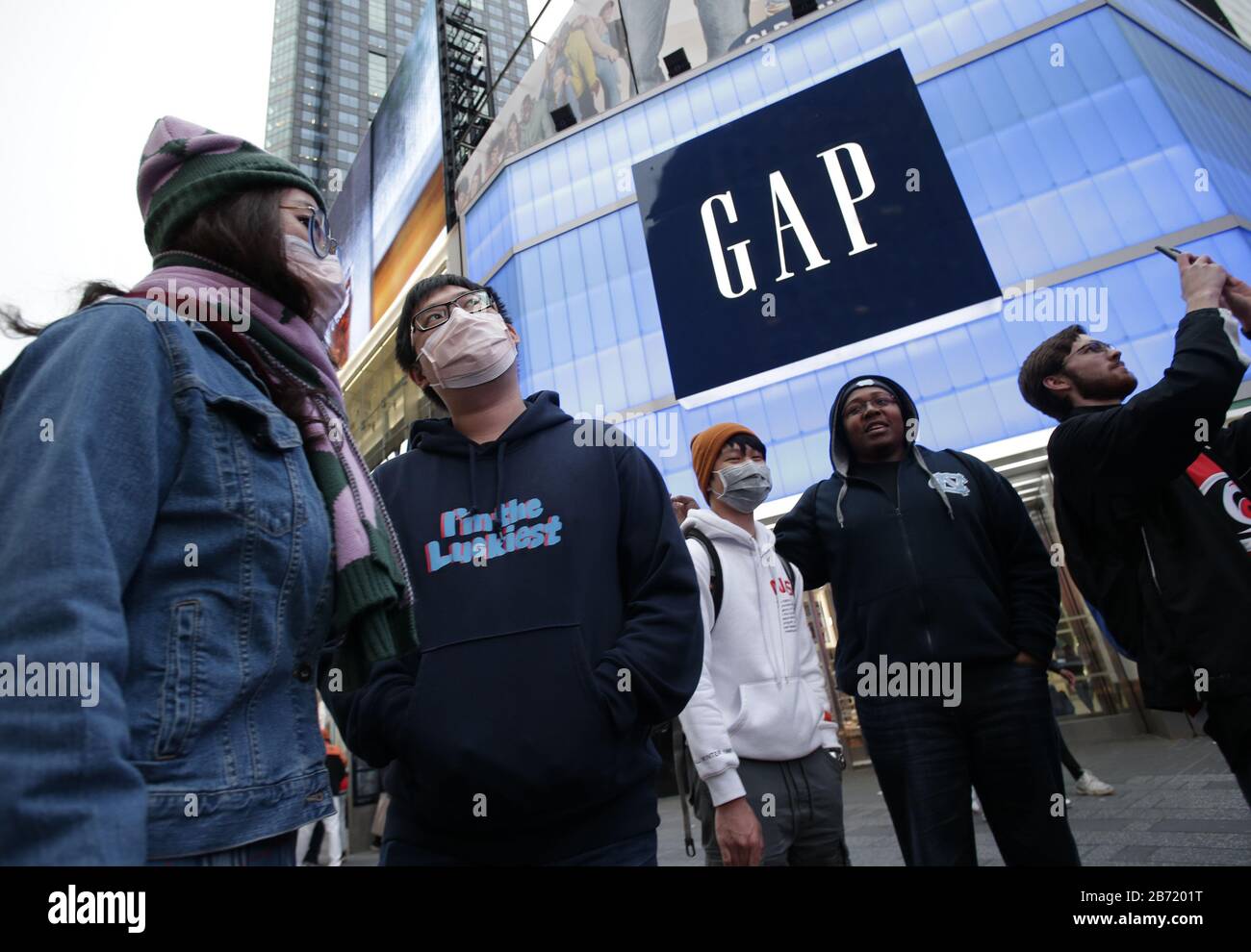 New York, United States. 12th Mar, 2020. Pedestrians wear face masks in Times Square in New York City on Thursday, March 12, 2020. Broadway is now shutting down all productions due coronavirus pandemic. Performances will be shut down for at least the dates between March 12 and April 12. Photo by John Angelillo/UPI Credit: UPI/Alamy Live News Stock Photo