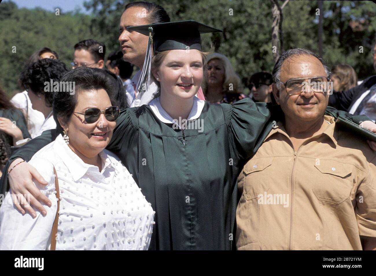 San Antonio, Texas New graduate poses for photo in cap and gown with