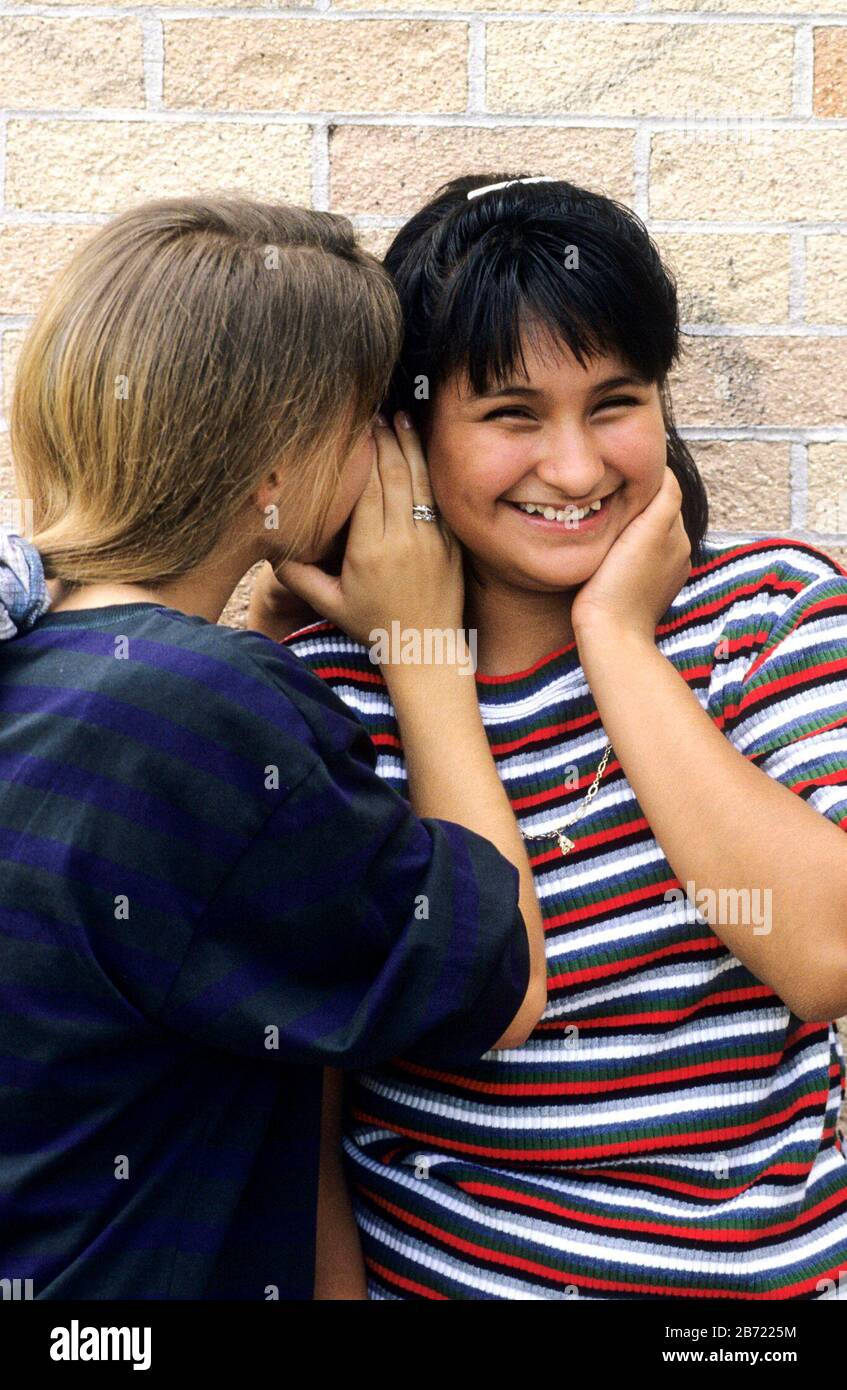 Austin Texas USA: Junior high schools girls share a secret outside of school. ©Bob Daemmrich / Stock Photo