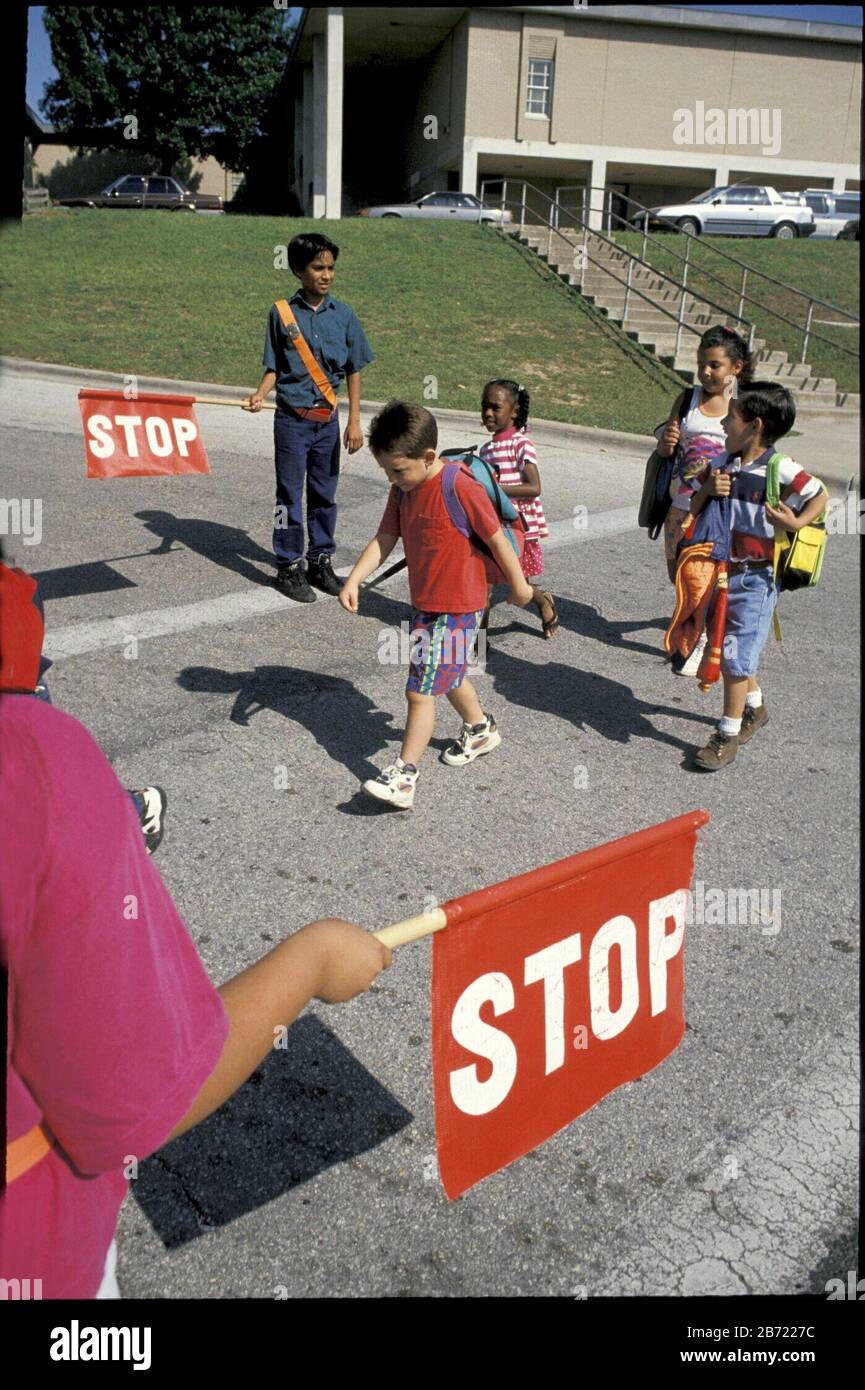 Austin Texas USA: Texas: Elementary school students serve as safety guards as younger students cross street in front of school building.  MR ©Bob Daemmrich Stock Photo