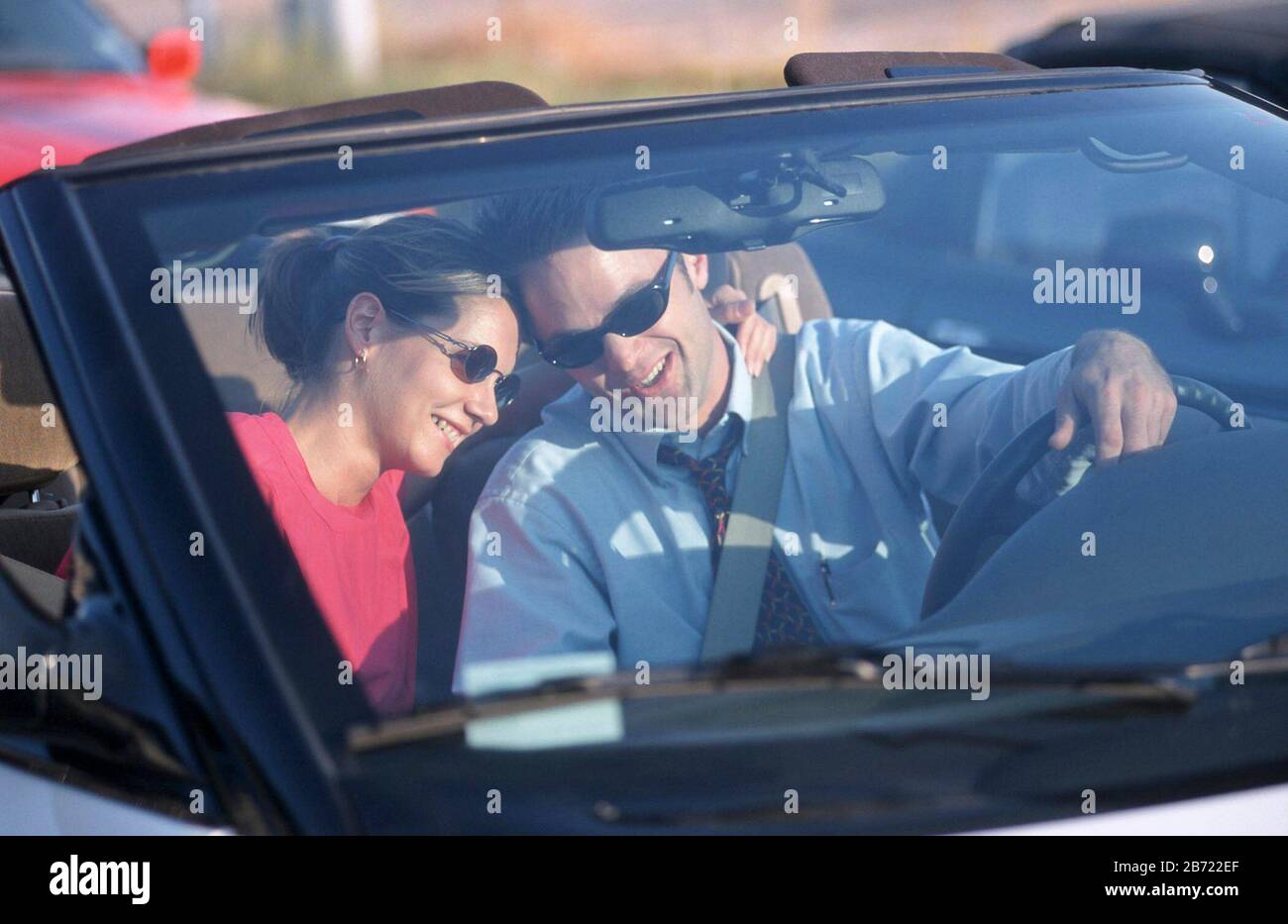 Austin, Texas USA: Happy couple in their early 30's enjoy each other's company while driving in convertible.  MR ©Bob Daemmrich Stock Photo