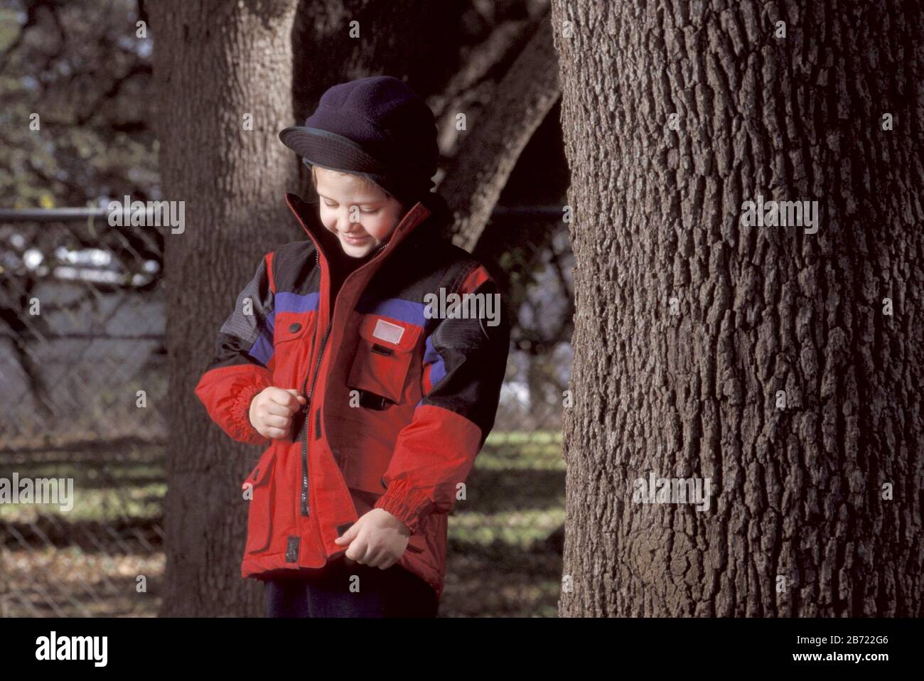 Austin, Texas USA: 5-year-old boy unzipping warm coat on chilly autumn day. ©Bob Daemmrich Stock Photo