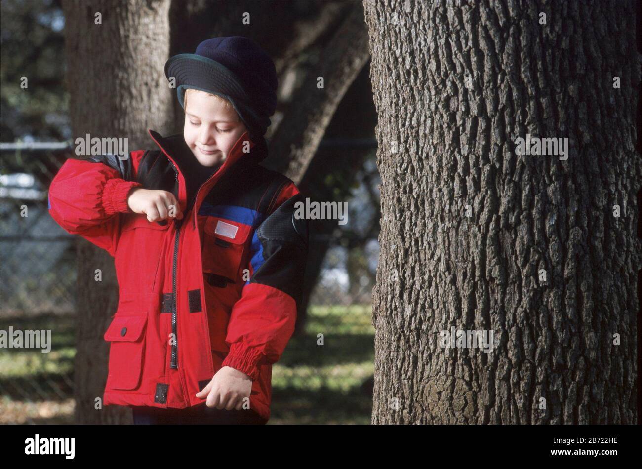 Austin, Texas USA: 5-year-old boy zips up warm coat on chilly autumn day. ©Bob Daemmrich Stock Photo