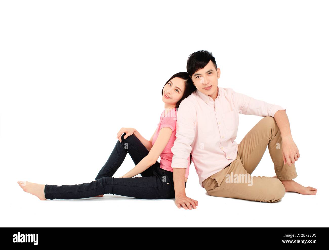 asian young couple sitting on floor isolated on white background Stock Photo