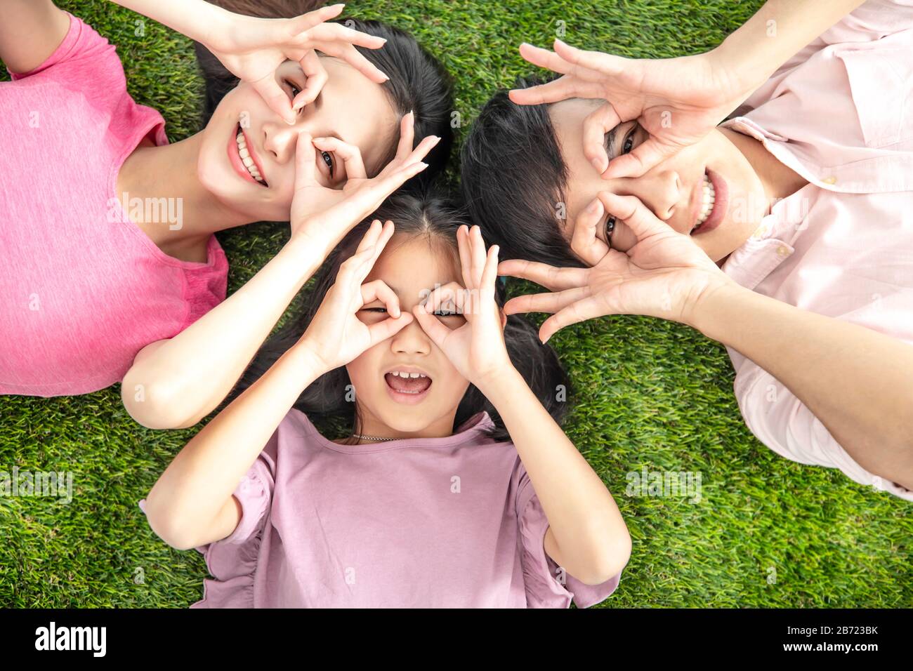 top view of Happy Young Family lying on the grass Stock Photo