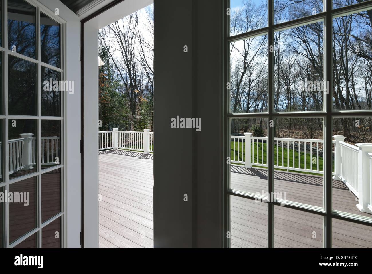 Garden deck view through the window glass. French door opening to large deck. Stock Photo