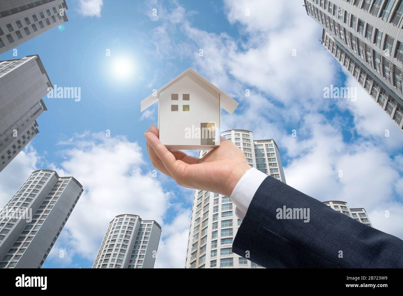 Businessman with house model on hand. Real estate concept Stock Photo
