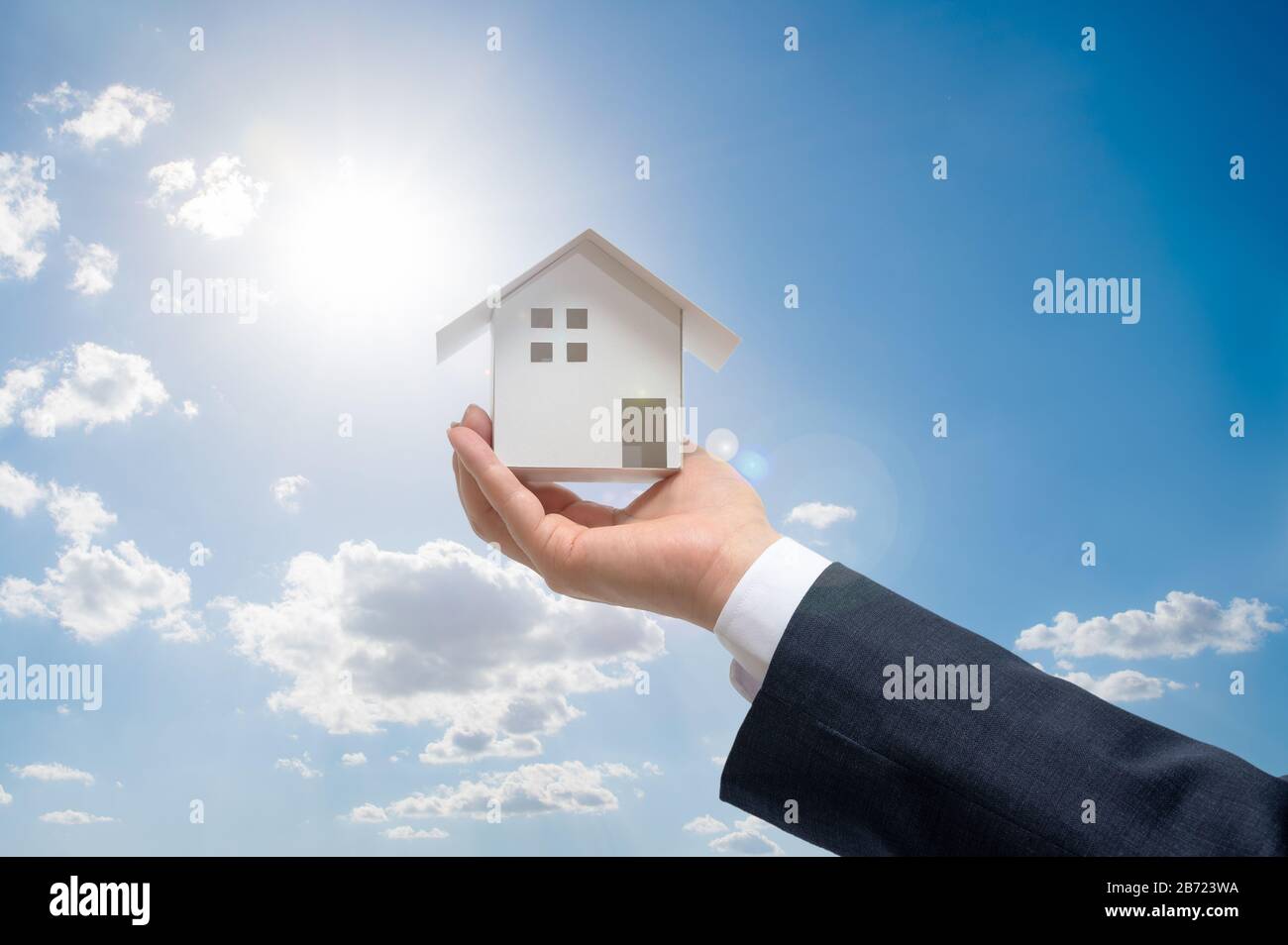 Businessman with house model on hand. Real estate concept Stock Photo