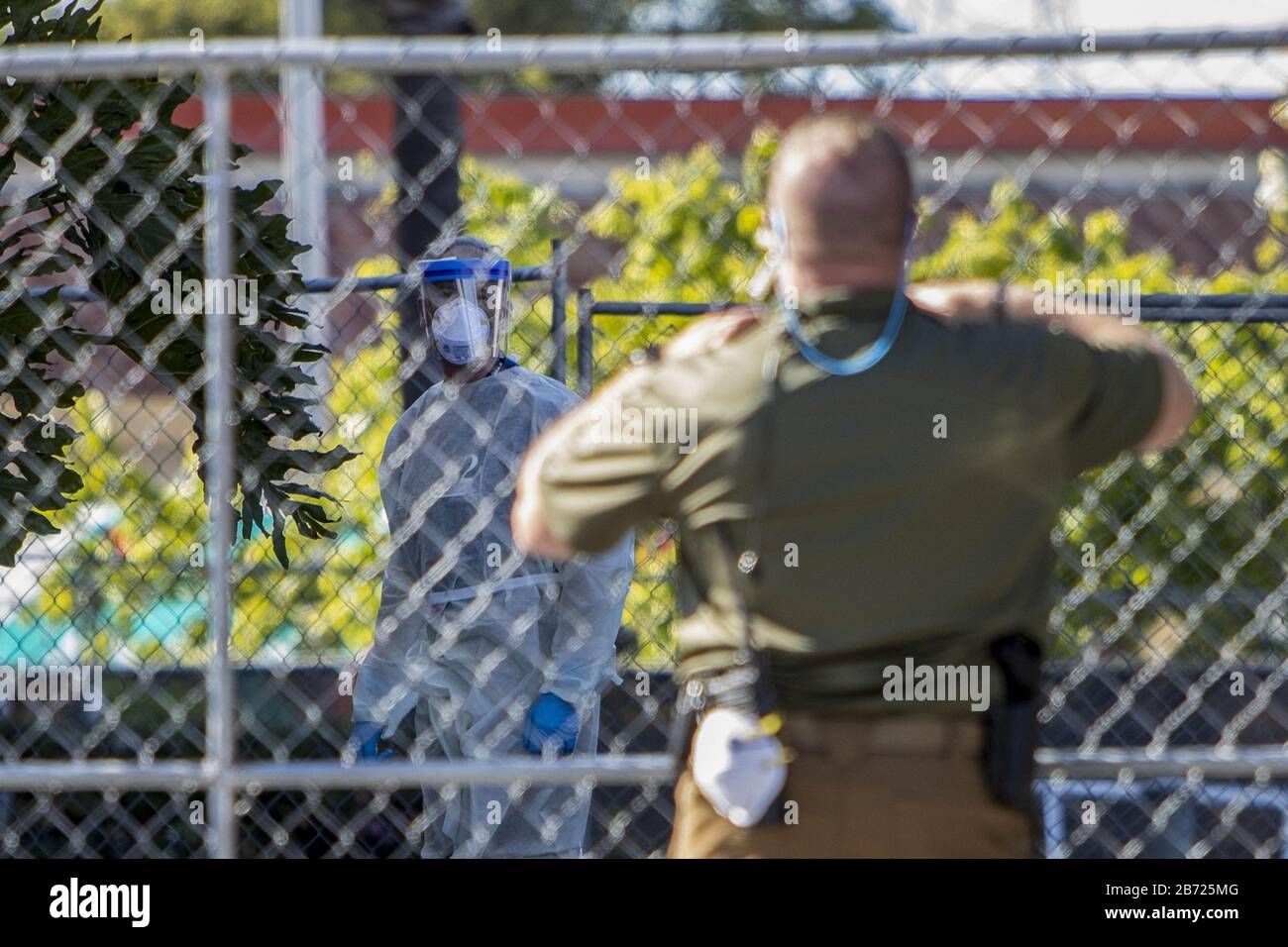 San Carlos, United States. 12th Mar, 2020. An unidentified health worker looks on from behind a chain linked fence surrounding the Fairfield Inn, a hotel purchased by the State of California to be used as a quarantine facility for CCOVID-19 patients, as he chats with a US Marshal that is guarding the facility in San Carlos, California on Thursday, March 12, 2020. Photo by Peter DaSilva/UPI Credit: UPI/Alamy Live News Stock Photo