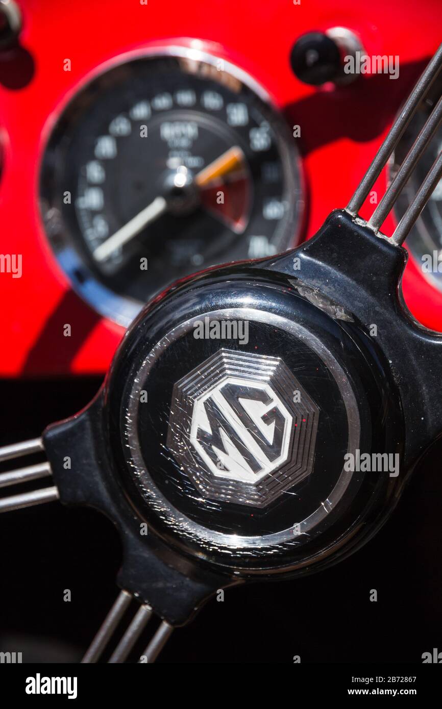 Centre of steering wheel with metal spokes and red dashboard in classic