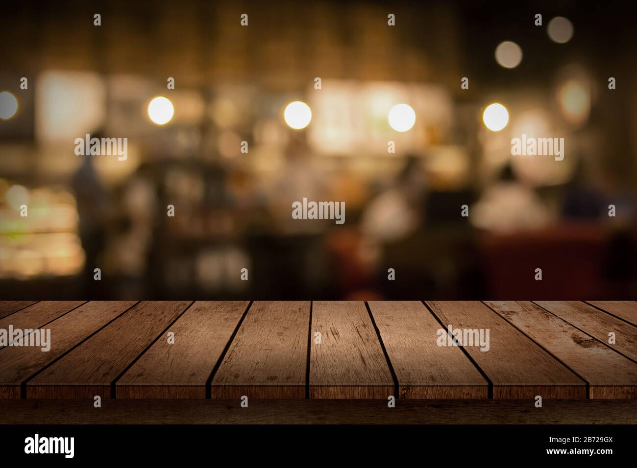 Wood table top on blur bokeh coffee shop or cafe restaurant background. Can be used for display or montage your products. Stock Photo