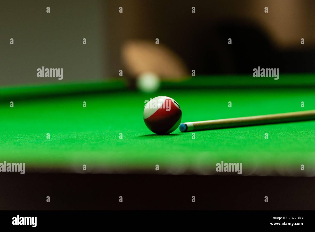 Pool table with stick and ball in a club house Stock Photo