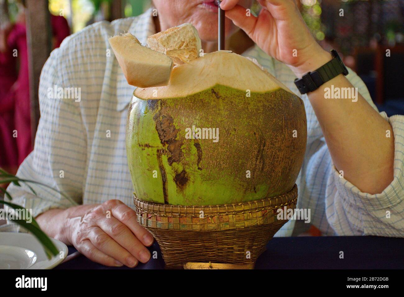 Midsection of woman juce from coconut Stock Photo
