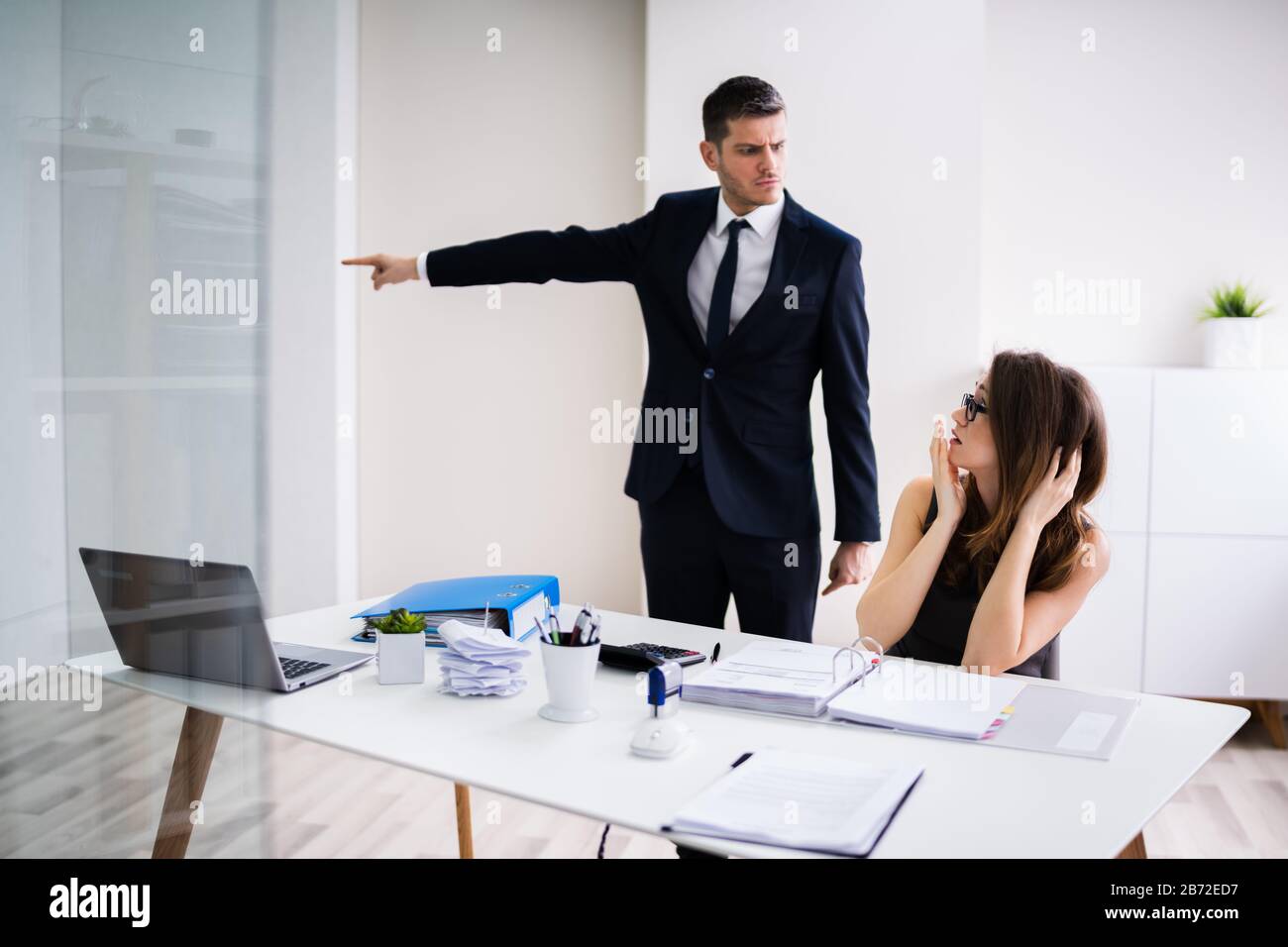 Boss Firing Female Employee In Modern Office Stock Photo