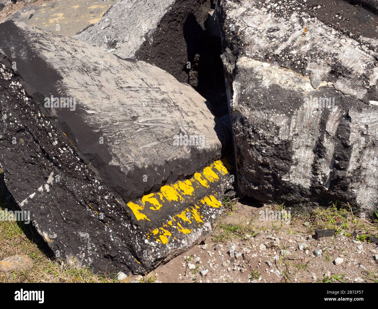 Massive Sections of Road Pavement and Roadbed at Demolition Site, Double Yellow Line painted on pavement, close-up view Stock Photo