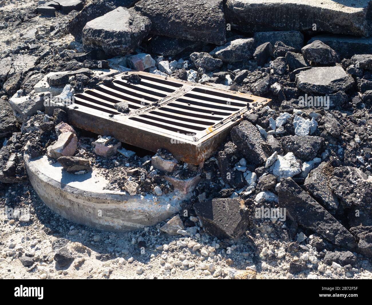 Road Demolition Debris, Metal Grill over Sewer Pipe, chunks of concrete