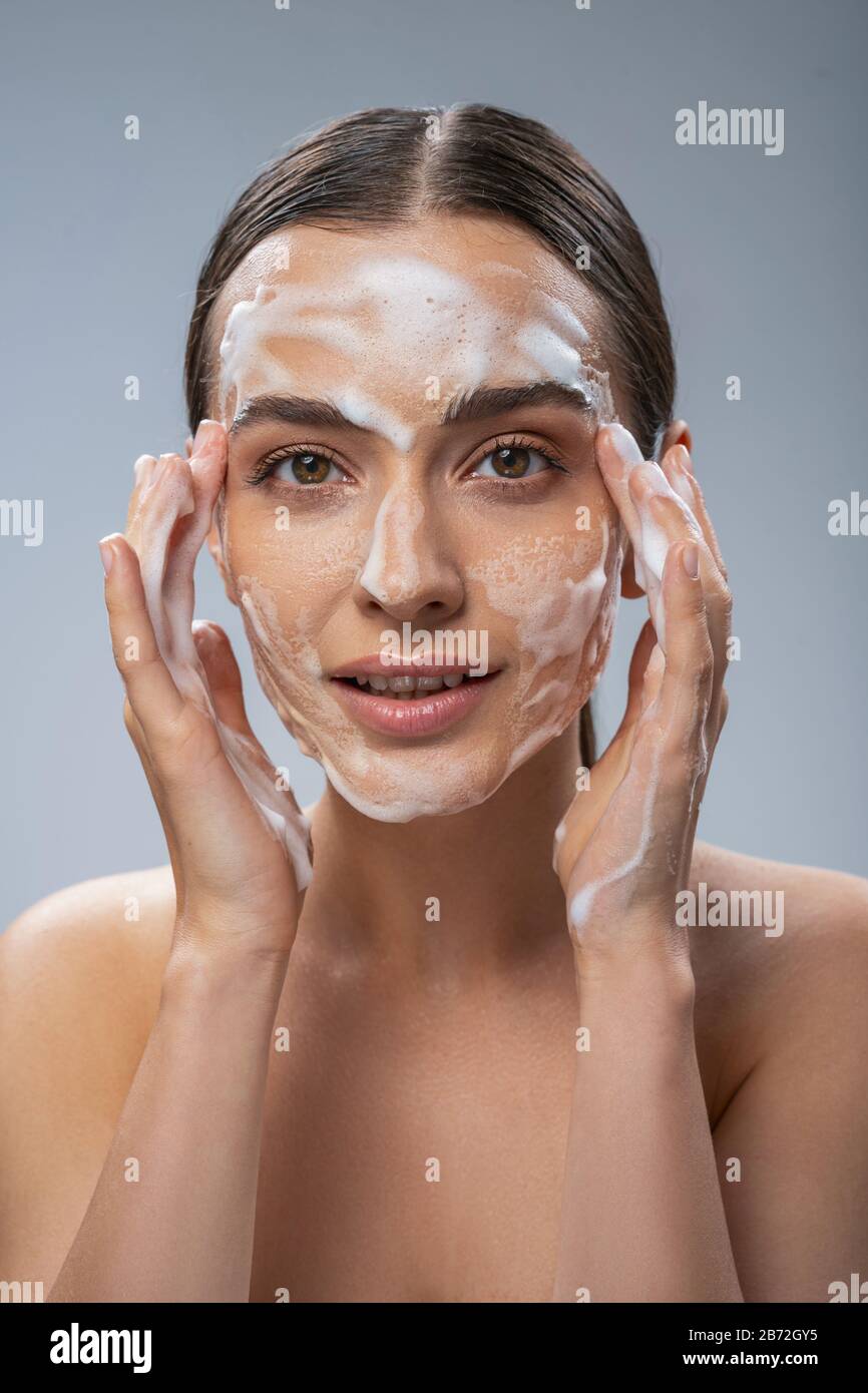 Happy pretty woman washing her face with soap Stock Photo Alamy