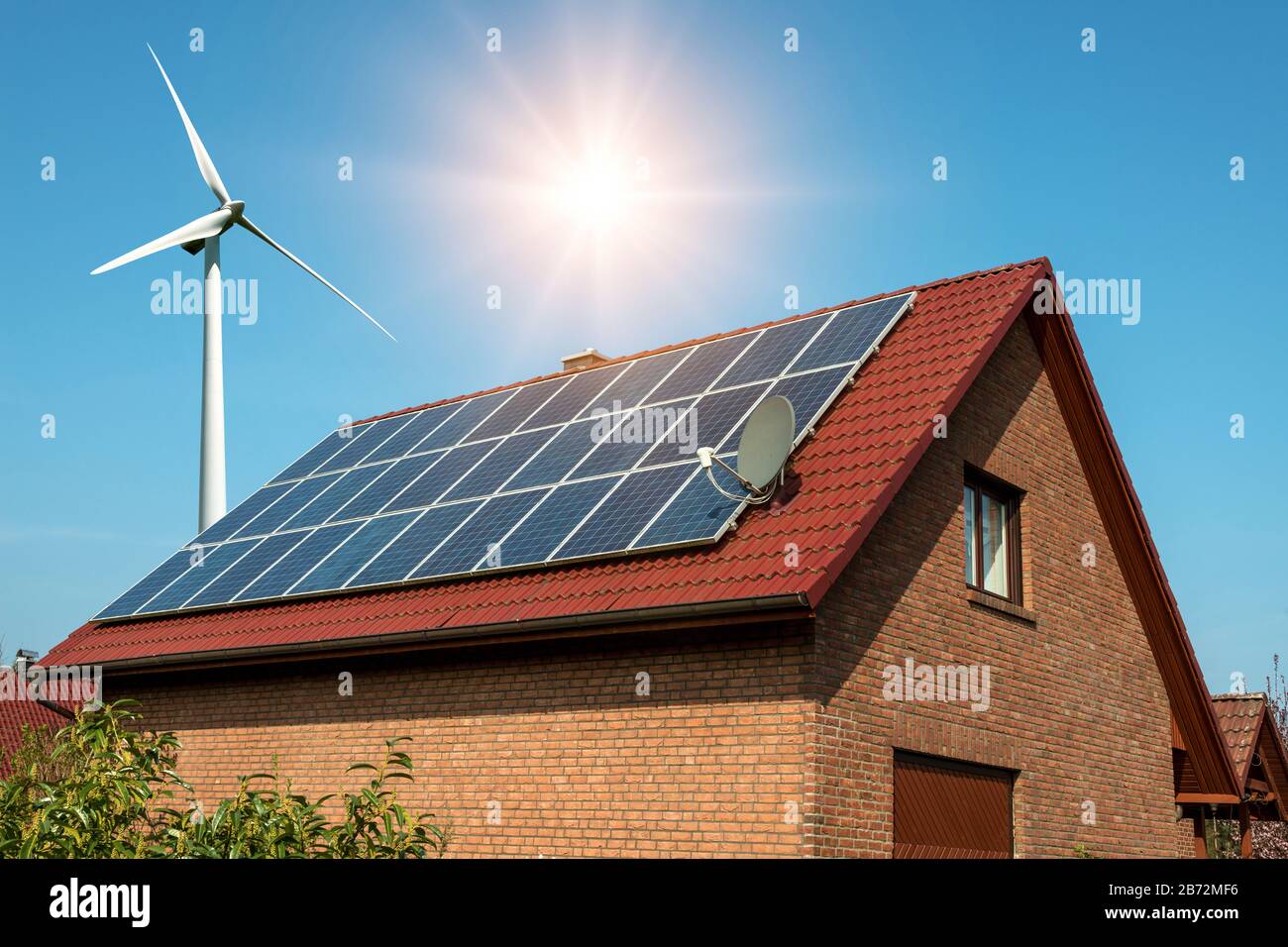 Solar panel on a roof of a house and wind turbins arround - concept of ...