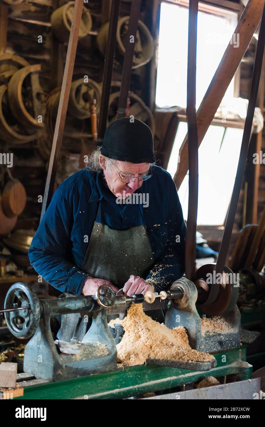 Forgotten era as old wood turner works his lathe in the replical wood workers shop in the replica town of Sovereign Hill in Ballarat, Victoria. Stock Photo