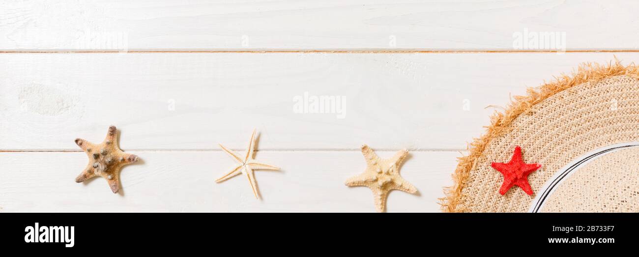 Straw hat and starfish On a white wooden background. top view summer ...