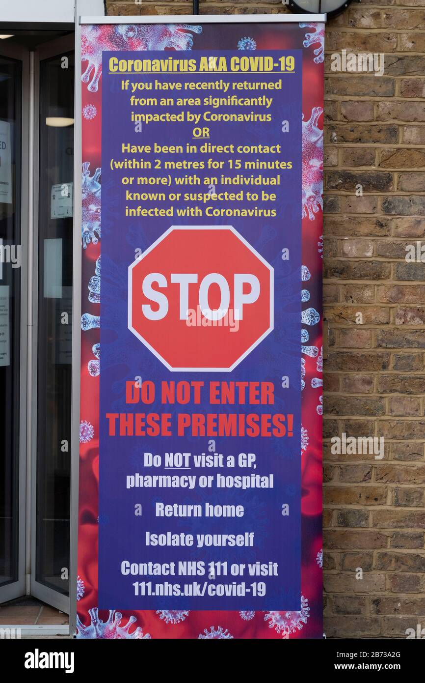 Berkhamsted, Hertfordshire, UK. 13th March, 2020. The NHS in England has given signage to Doctor’s surgeries warning against patients entering, if they think that they have the symptoms of Coronavirus. A surgery in Berkhamsted, Hertfordshire displays signs outside the entrance. Photo: ©  David Levenson/Alamy Live News Stock Photo
