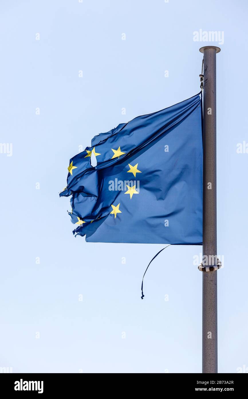 Europe - Torn European flag flutters in the wind at the flagpole, symbolic image of EUROPE IN CRISIS. Europa - Zerrissene Europafahne flattert am Fahn Stock Photo