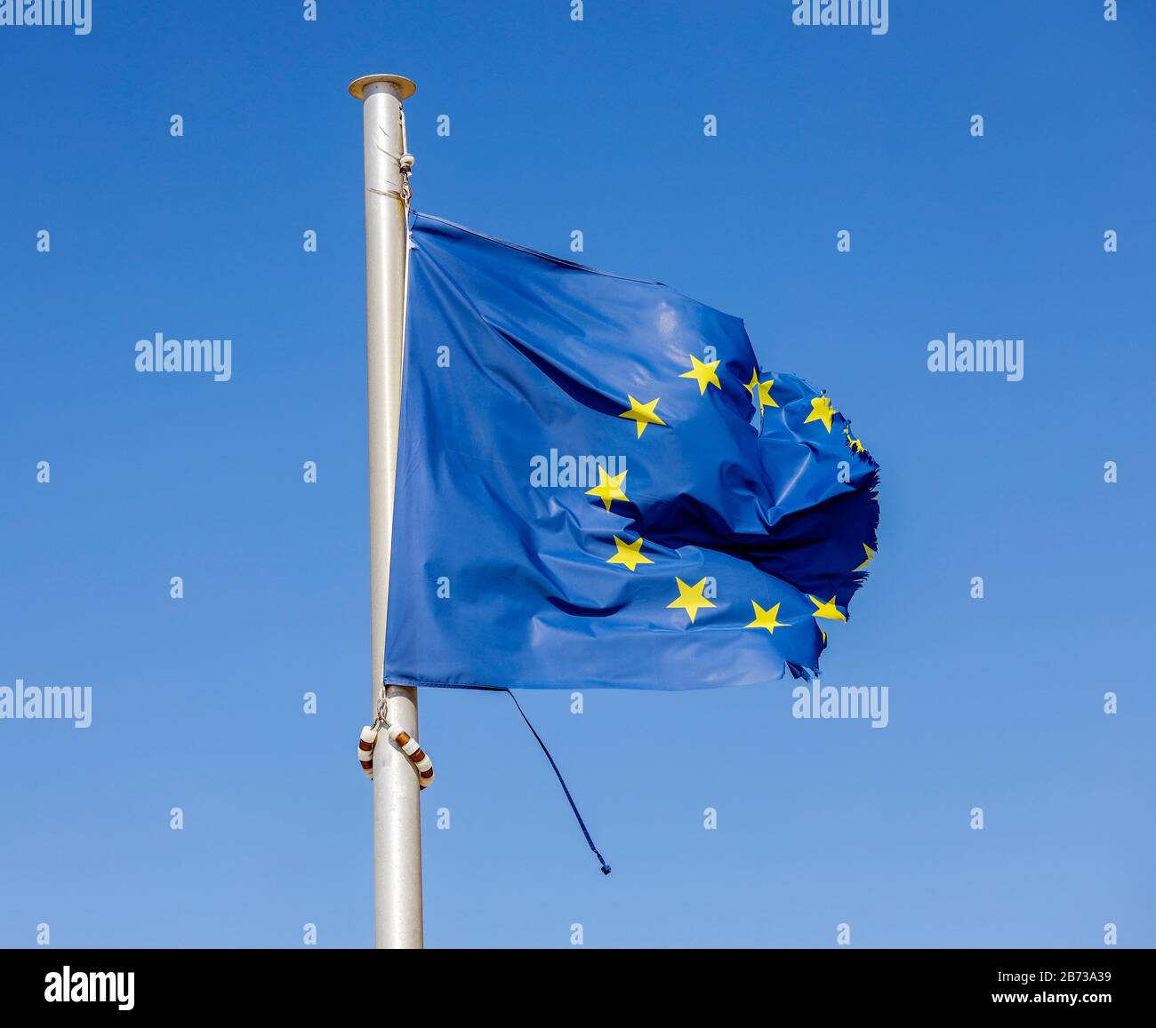 Europe - Torn European flag flutters in the wind at the flagpole, symbolic image of EUROPE IN CRISIS. Europa - Zerrissene Europafahne flattert am Fahn Stock Photo