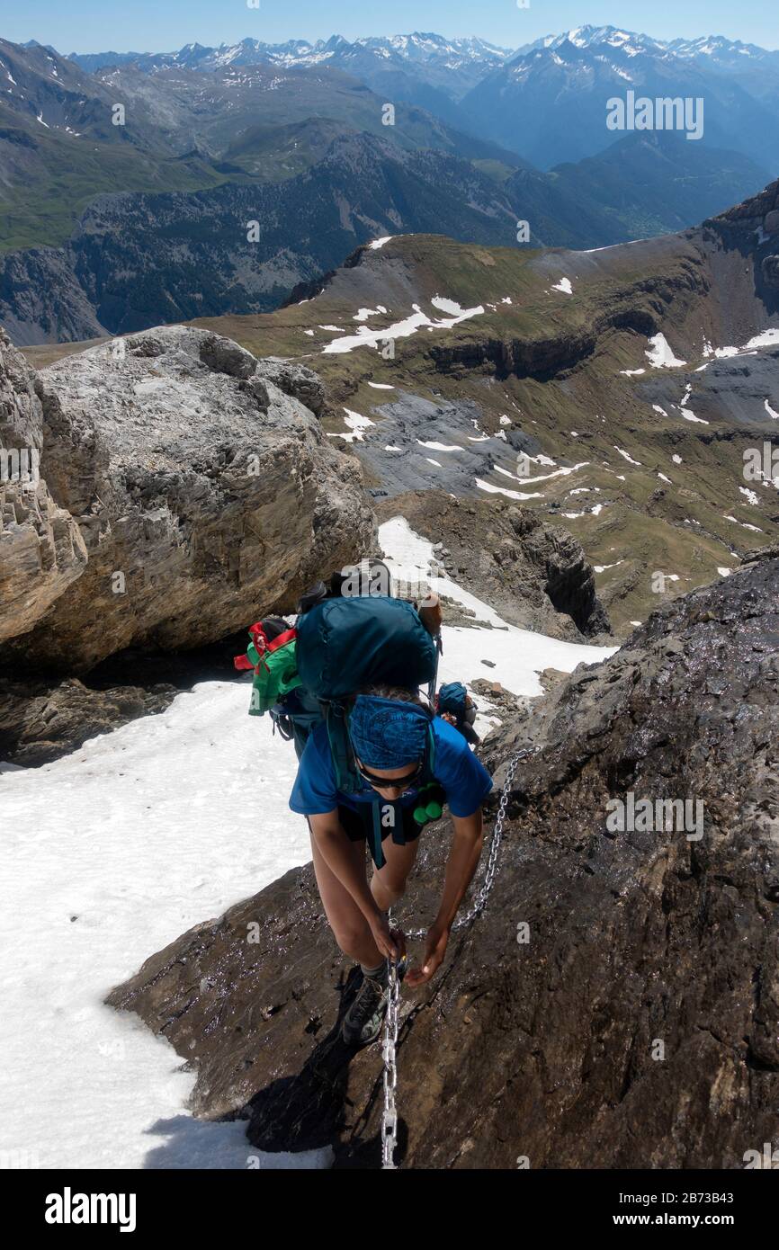 Woman using the fixed chains to climb at Faja de las Olas.Ordesa National Park.Pyrenees,Huesca.Spain Stock Photo