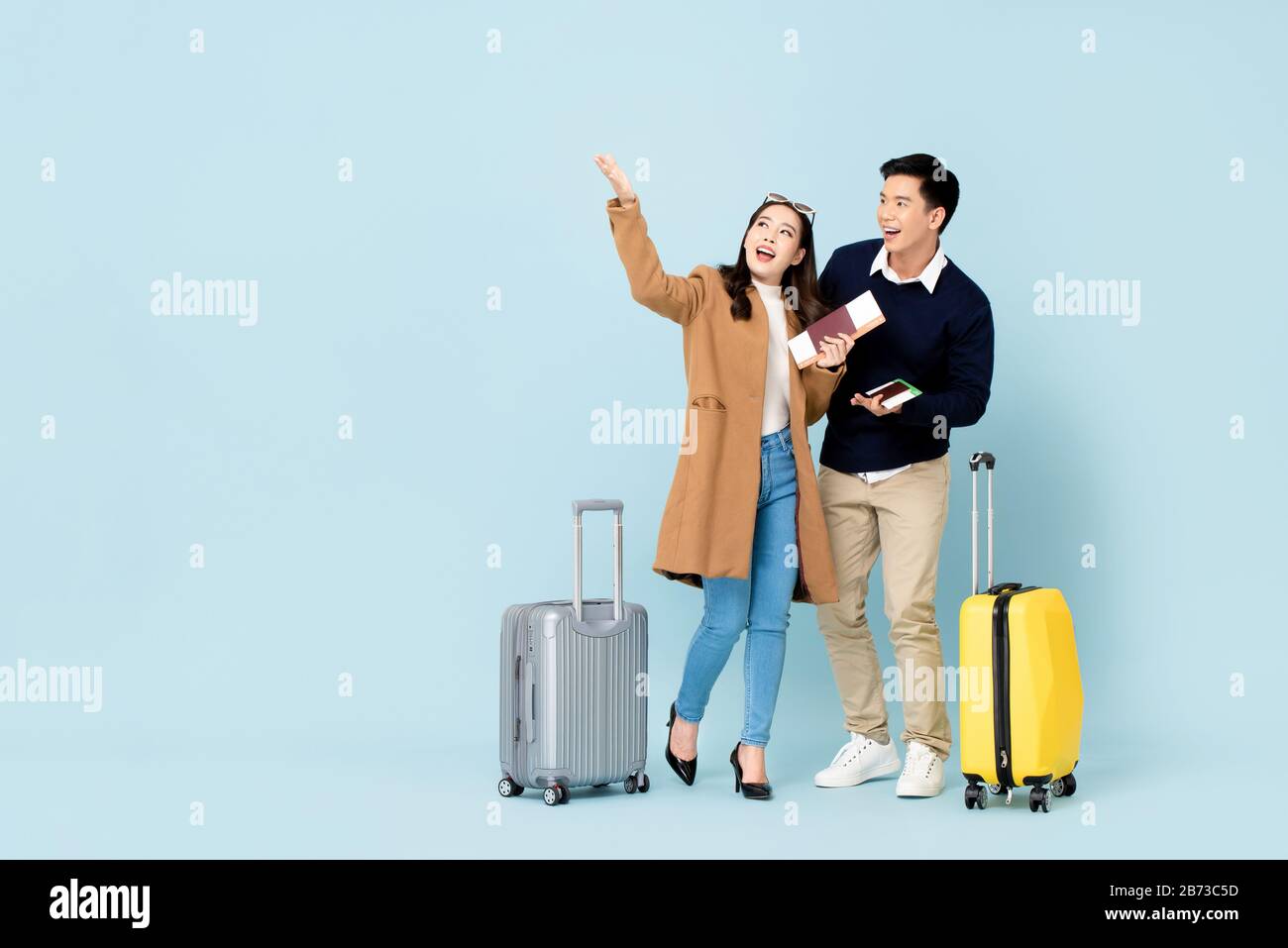 Lovely Asian couple tourists with baggage passports and boarding passes about to go for honeymoon travel Stock Photo