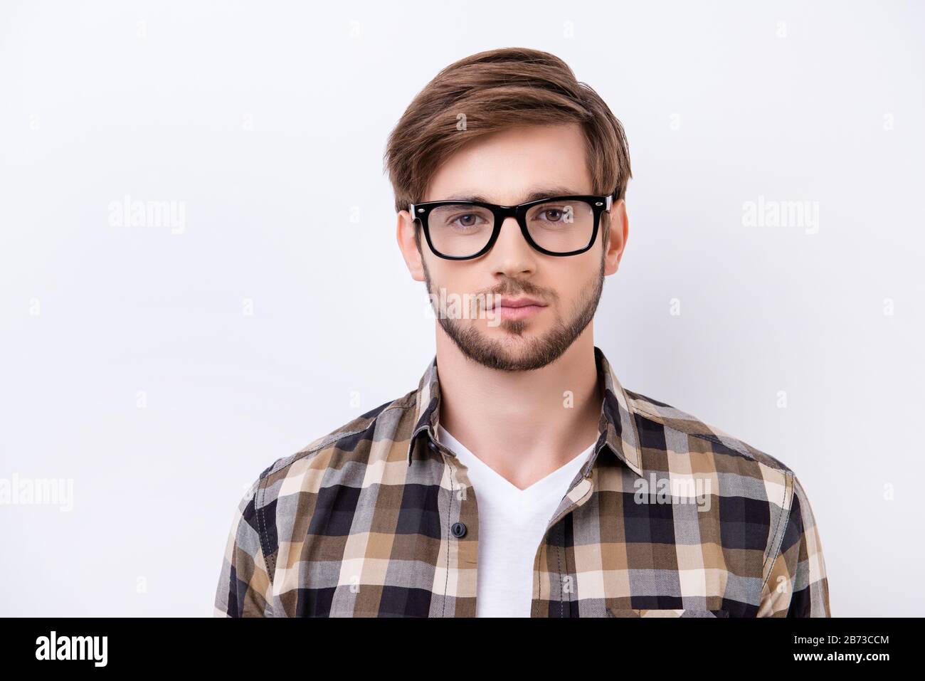 Portrait of smart young confident man in a checked shirt with glasses ...