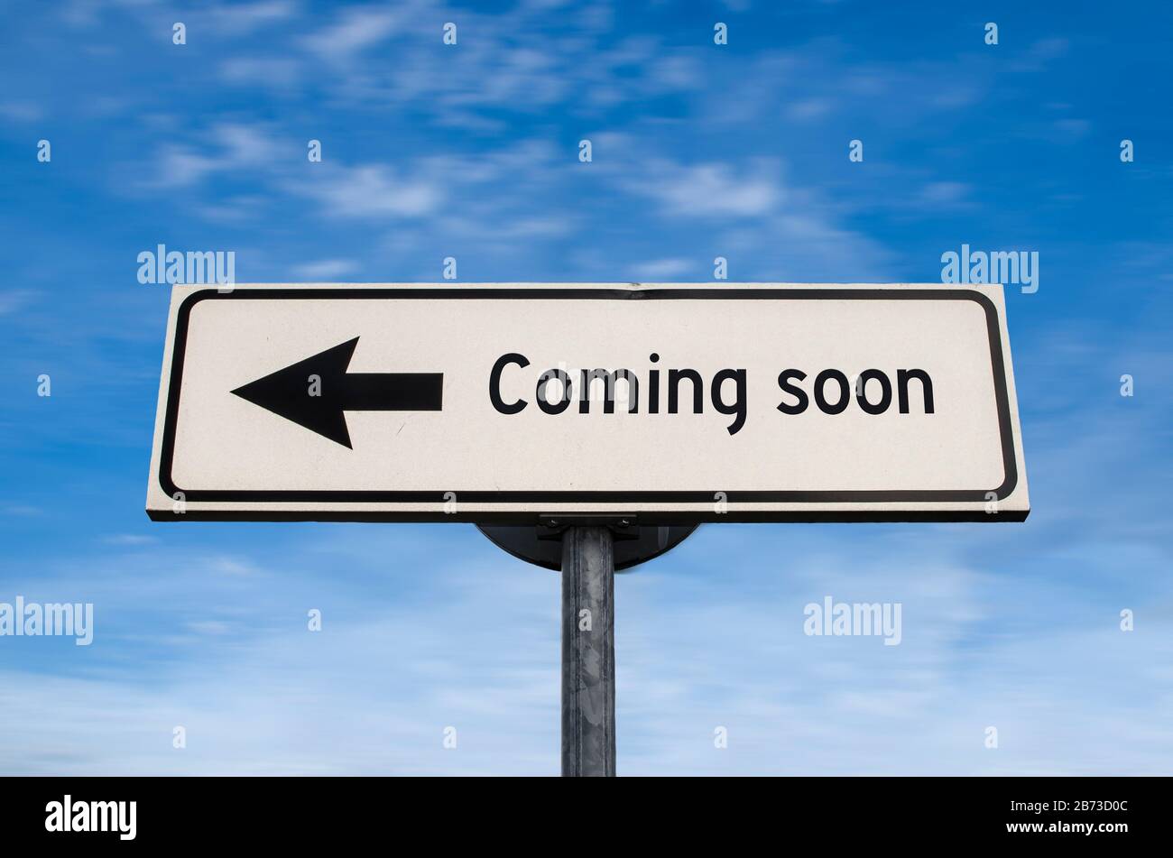 Coming soon road sign, arrow on blue sky background. One way blank road sign. Arrow on a pole pointing in one direction. Stock Photo