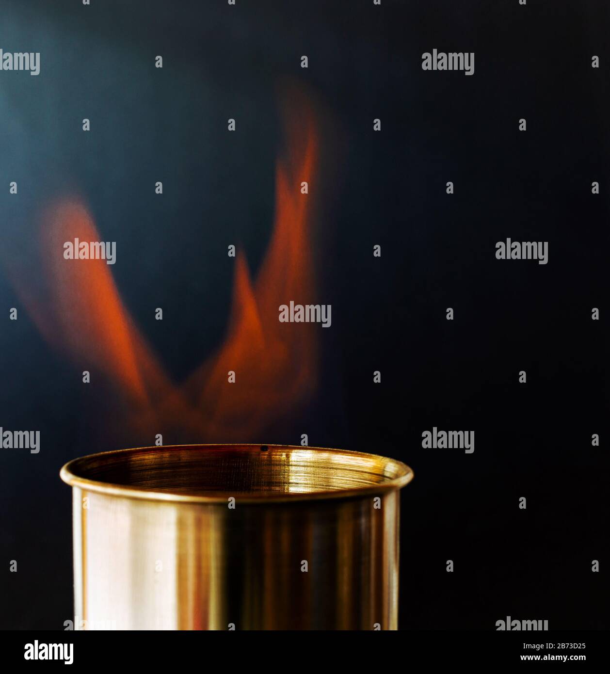 Flame, burning candle on a black background. Brass candle. Danger. Fire and smoke Stock Photo