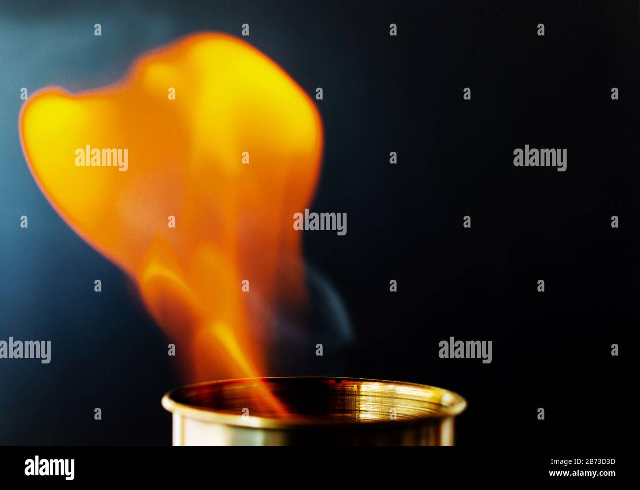 Flame, burning candle on a black background. Brass candle. Danger. Fire