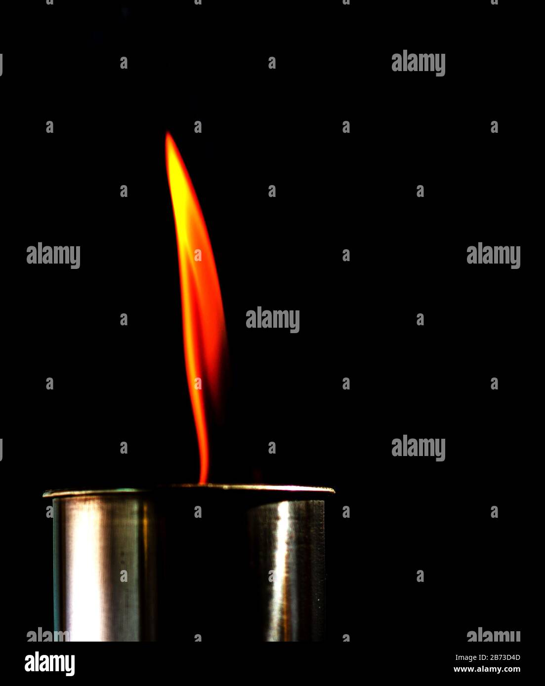 Flame, burning candle on a black background. Brass candle. Danger. Fire
