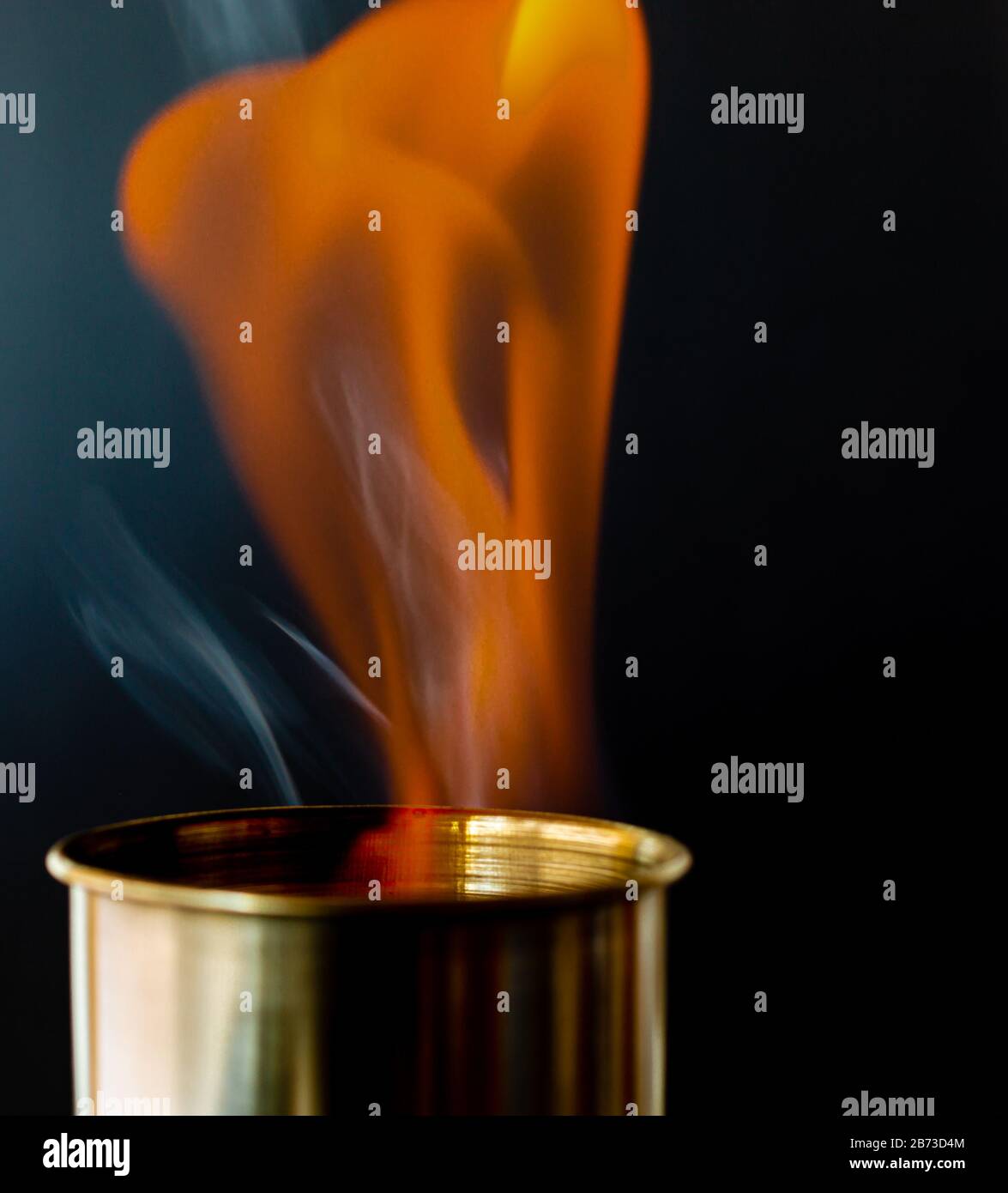 Flame, burning candle on a black background. Brass candle. Danger. Fire