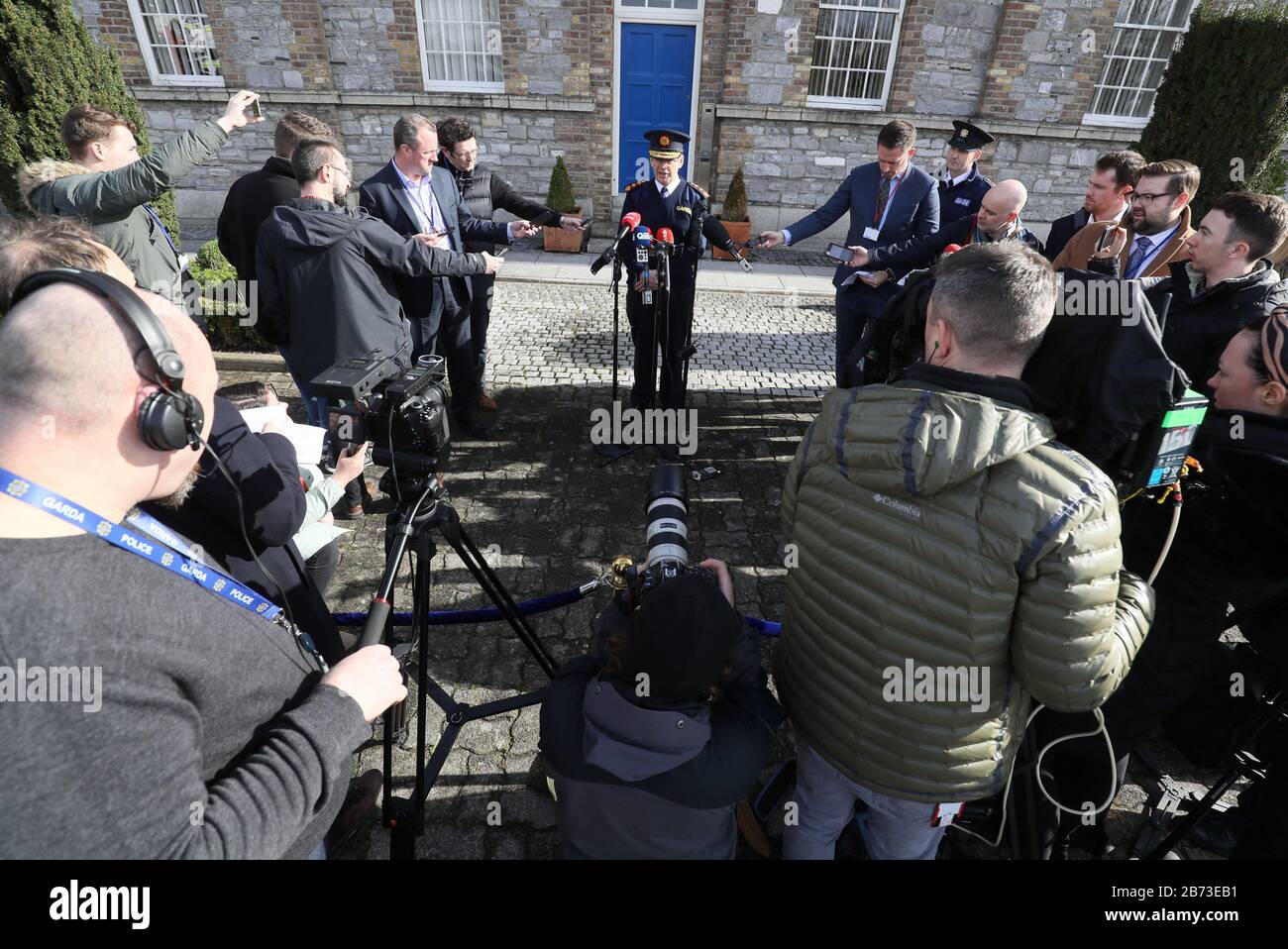 Journalists attempt to keep a safe distance from Garda Commissioner Drew Harris as he speaks at a press conference on coronavirus outside Garda Headquarters in Dublin. Stock Photo
