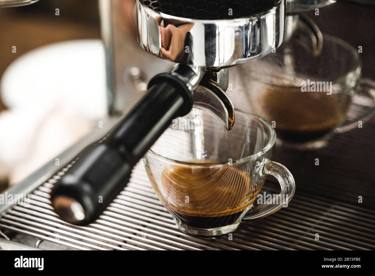 Two espresso cups getting filled in a portafilter machine Stock Photo -  Alamy