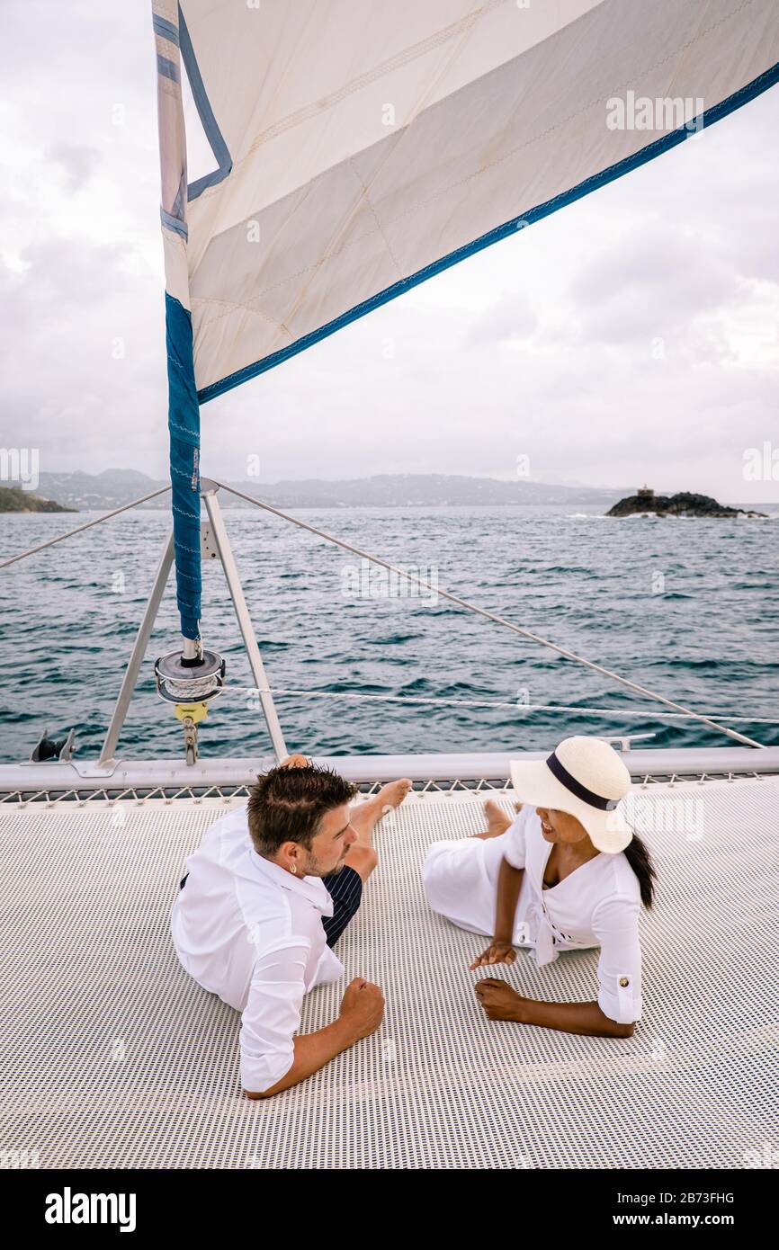 St Lucia, couple men and woman watching sunset from sailing boat in the Caribbean sea near Saint Lucia or St Lucia Stock Photo