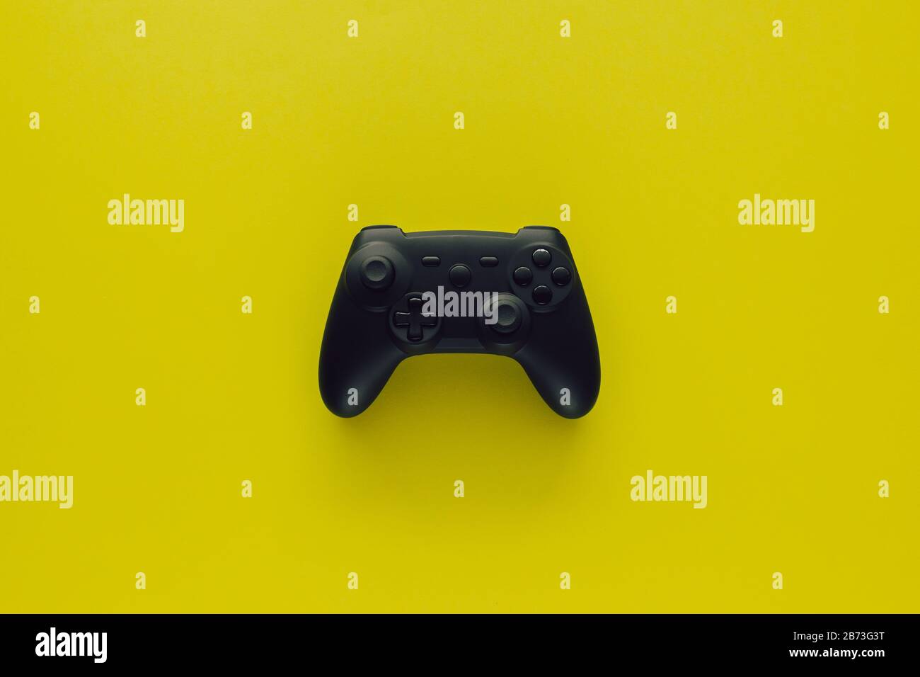 Stock photo of a black gamepad in the middle of a green background Stock Photo