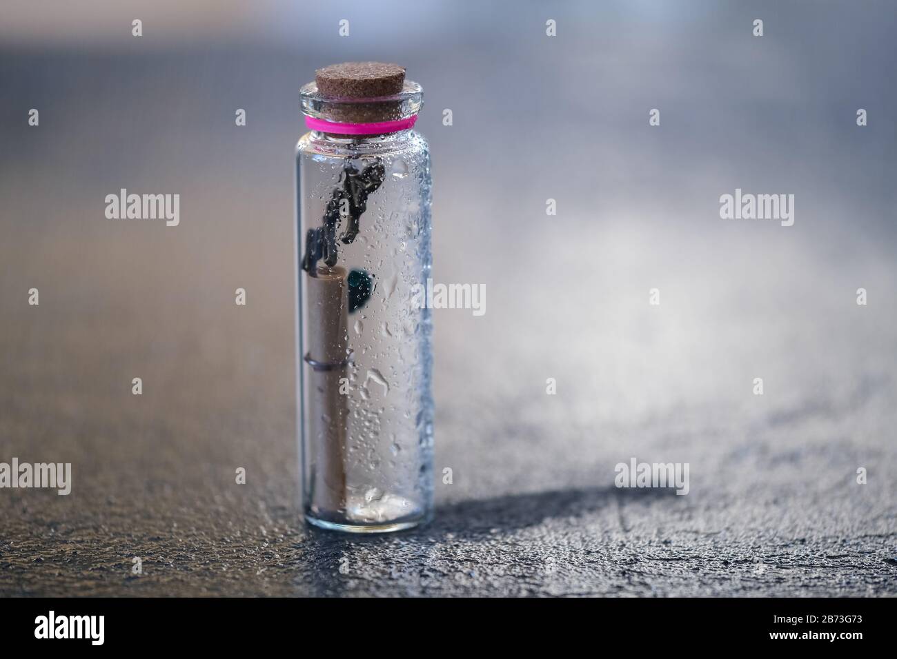 Closeup of a glass bottle with a rolled message inside stranded  with some blank space on top Stock Photo