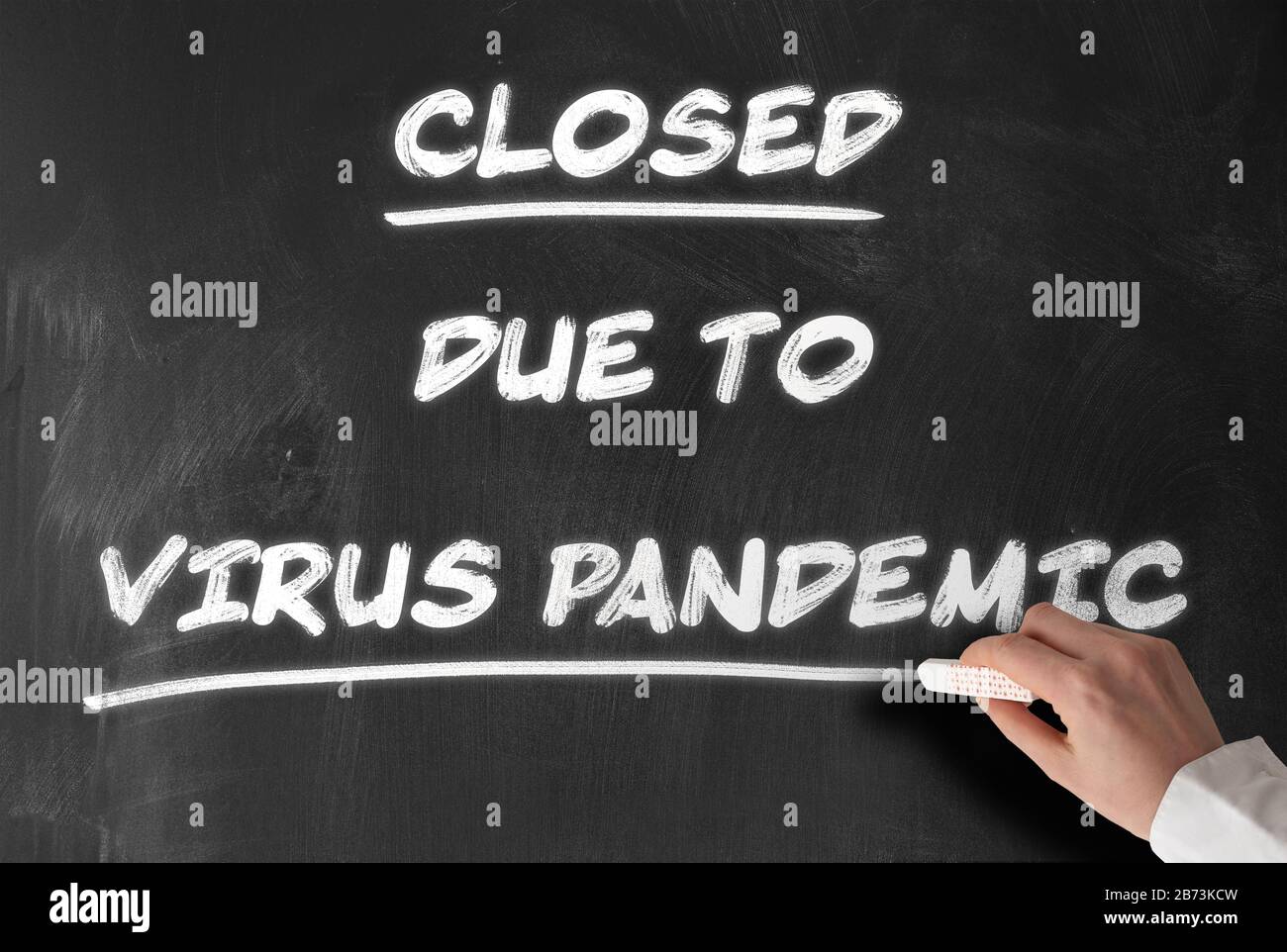 text CLOSED DUE TO VIRUS PANDEMIC written on chalkboard, closed schools and business during corona outbreak concept Stock Photo