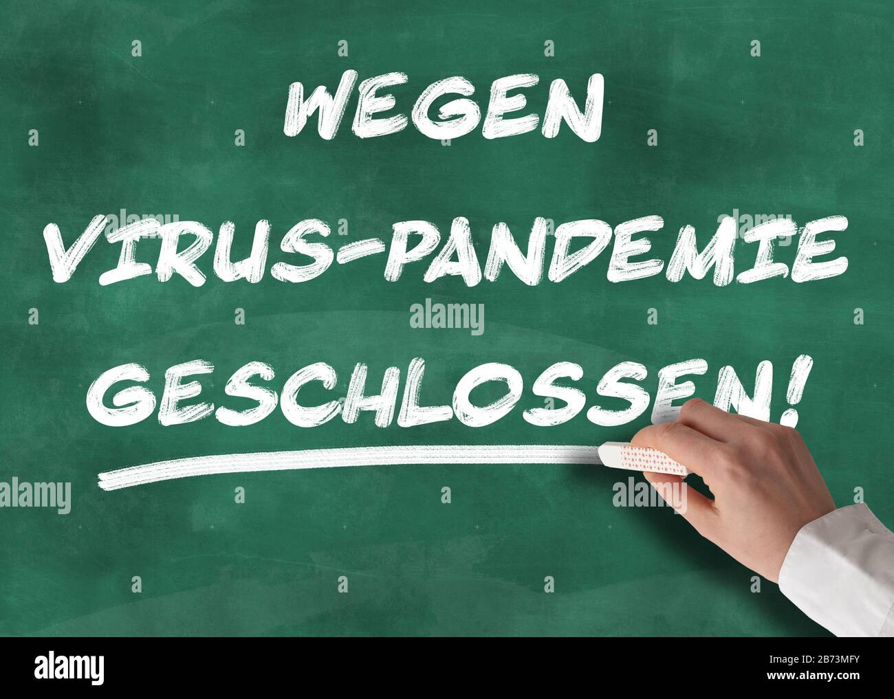 text WEGEN VIRUS-PANDEMIE GESCHLOSSEN on chalkboard, German for closed due to virus pandemic, schools and business closed during corona outbreak Stock Photo