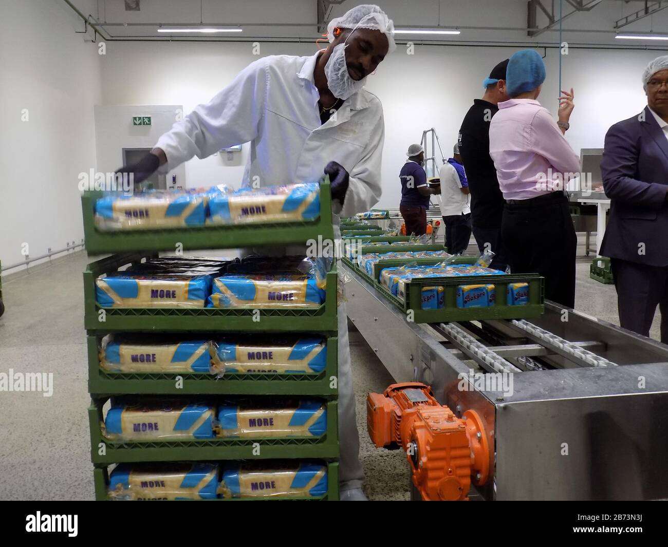 (200313) -- WINDHOEK, March 13, 2020 (Xinhua) -- A worker carries packaged bread at a bread manufacturing factory in Windhoek, Namibia, March 12, 2020. Namibia's Minister of Industrialization, Trade and SME Development Tjekero Tweya on Thursday inaugurated the country's first-ever state-of-the-art bread manufacturing factory valued at around 135 million Namibia dollars (about 8.4 million U.S. dollars). The factory system runs like a conveyor belt through the entire process of mixing, fermenting, baking and packaging. (Photo by Musa C Kaseke/Xinhua) Stock Photo