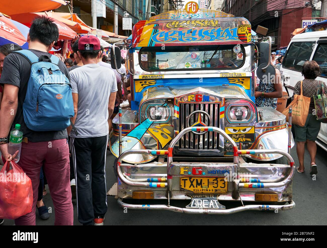 Divisoria Market, Manila, Philippines: Front view of colourful jeepney, traditional transportation, surrounded by busy shoppers Stock Photo
