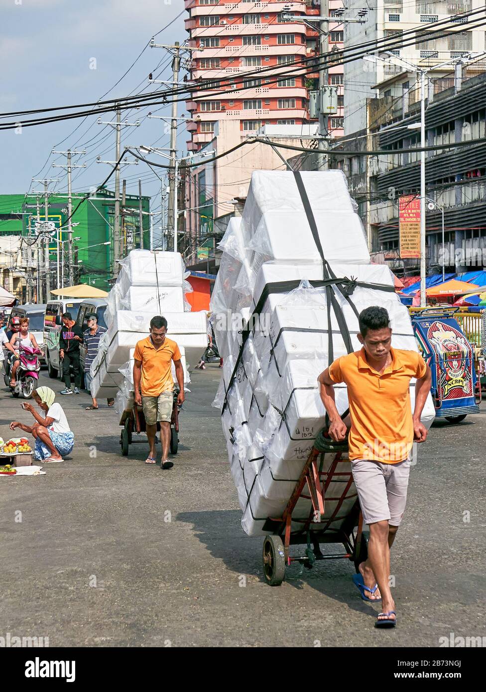 Divisoria Market, Manila, Philippines : Two male porters moving a high load of styrofoam boxes with a transport cargo trolley Stock Photo