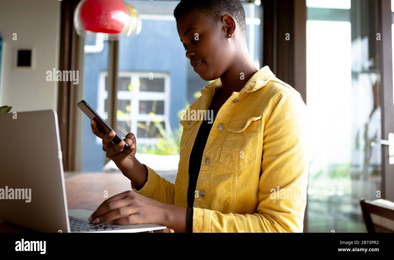 Woman working on laptop while sitting at table Stock Photo