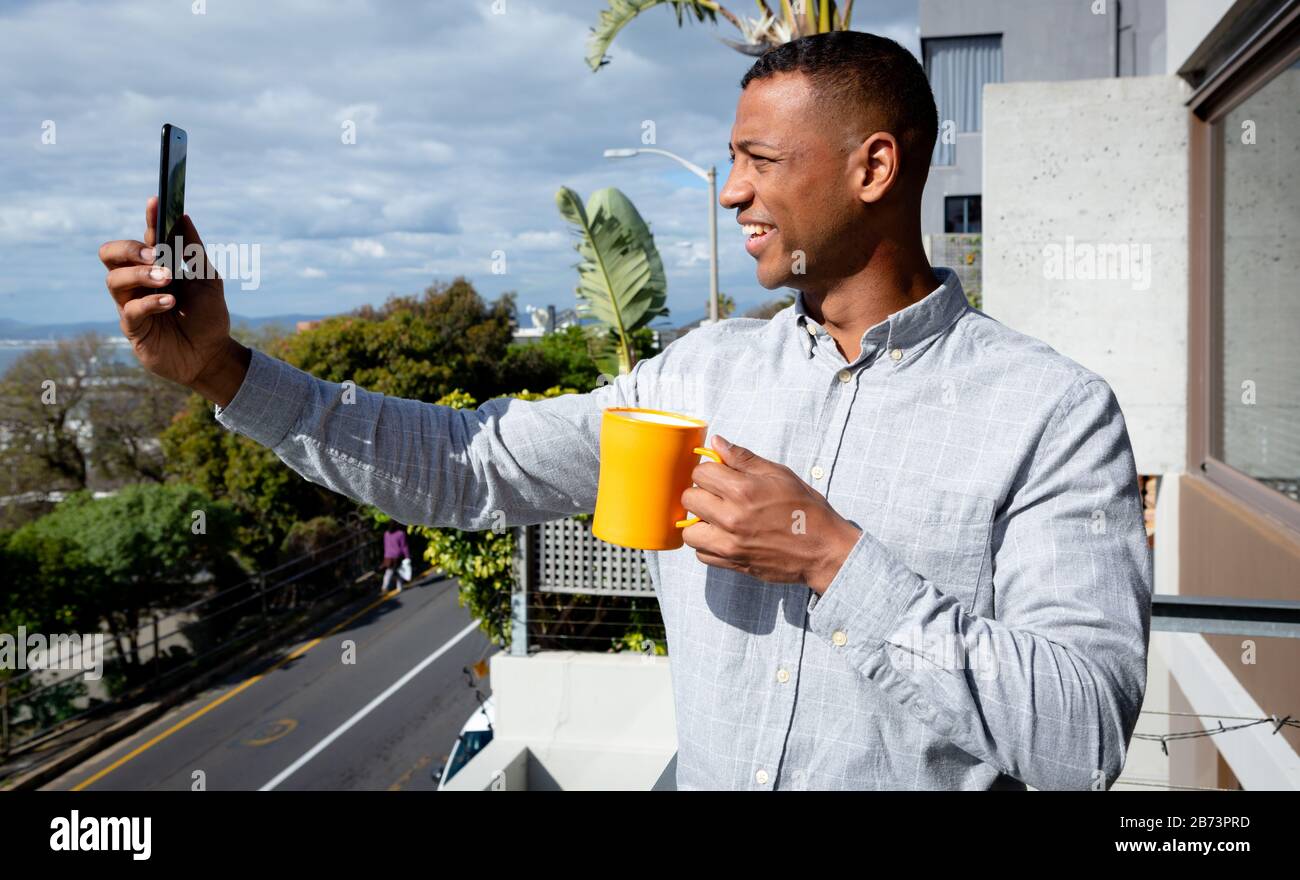 Man using his phone and drinking coffee Stock Photo