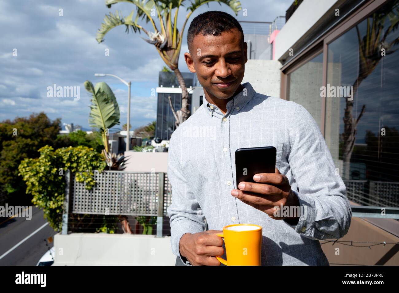 Man using his phone and drinking coffee Stock Photo
