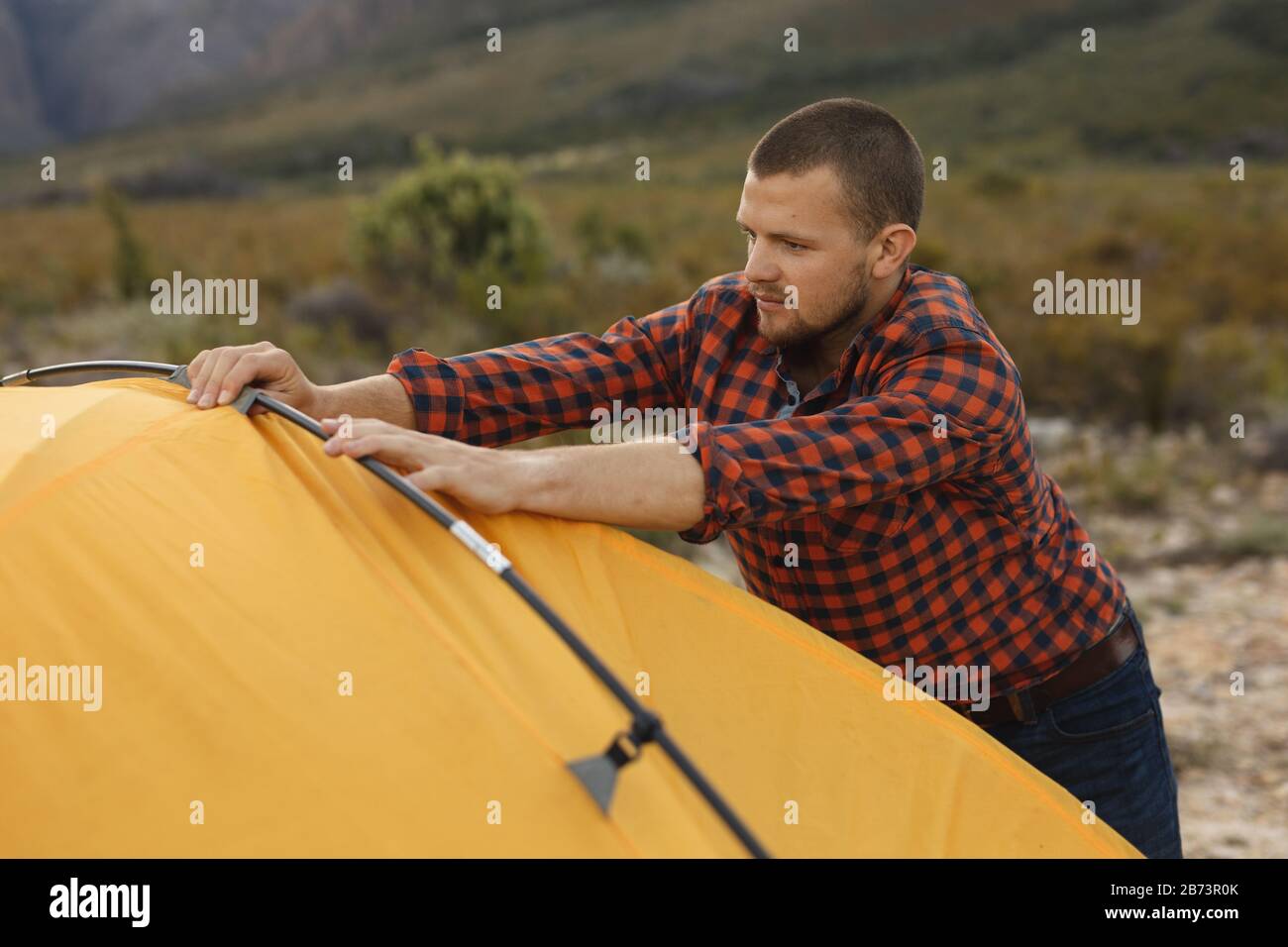 Side view of man installing the tent Stock Photo