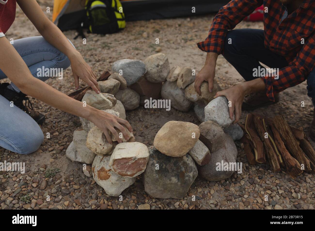 Side view of couple installing rocks for a campfire Stock Photo